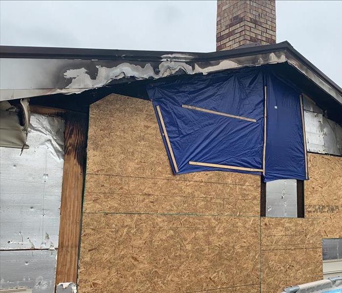 house boarded up and tarped after fire
